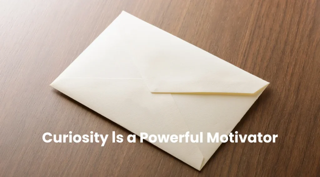 An envelop on a wooden table. The words “Curiosity is a powerful motivator,” overlay the image.