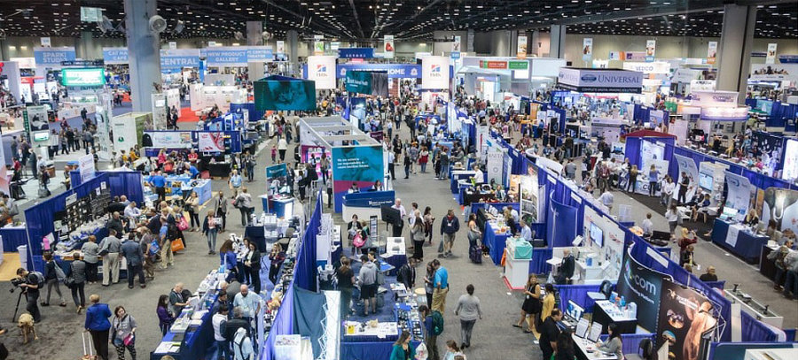 The exhibitor's floor at a live event filled with booths and people